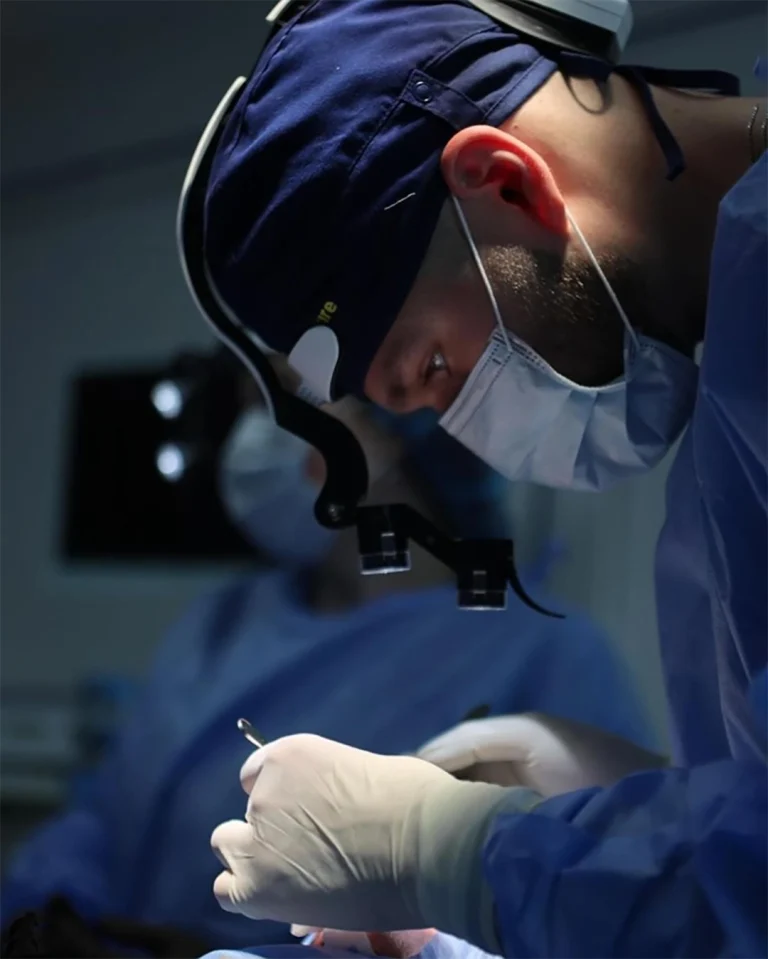 Odontólogo con lupas con luz led Bilumix durante un procedimiento dental