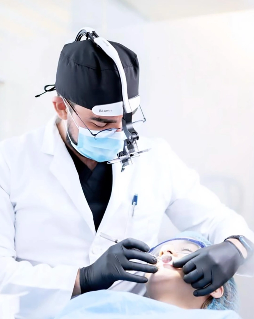 Odontólogo realizando un tratamiento con lupas dentales con luz LED Bilumix