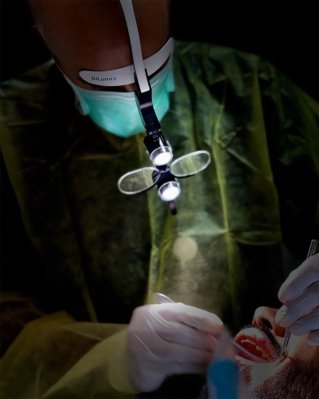 Odontólogo trabajando con lupas dentales de aumento durante un tratamiento