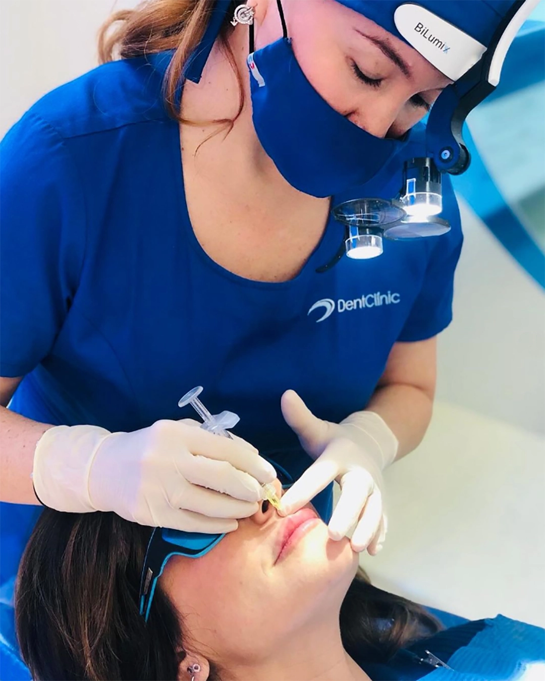 Odontóloga trabajando con lupas de aumento Bilumix en una clínica